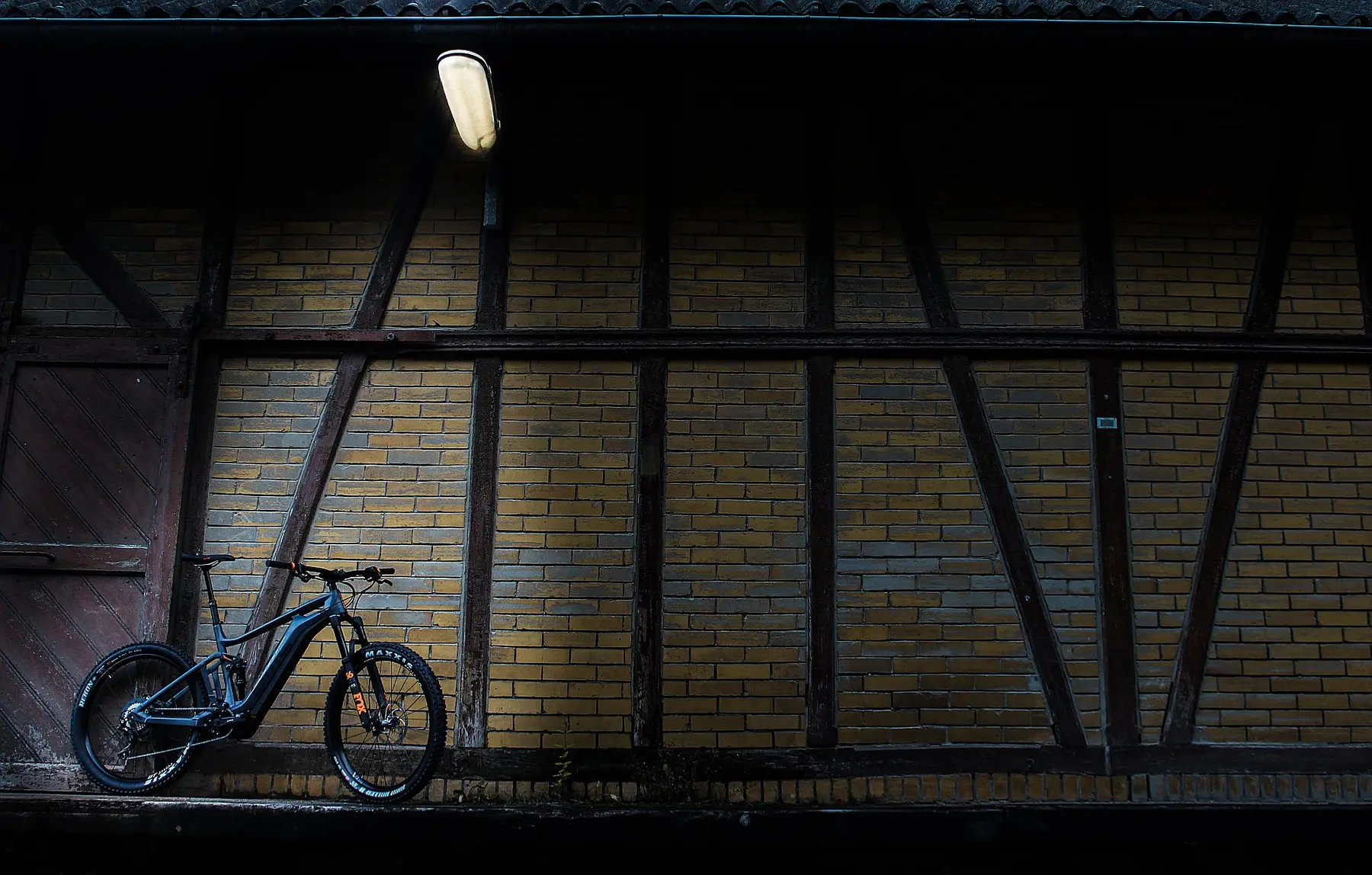 E-Mountainbike vor einer Fachwerkwand in der Dämmerung