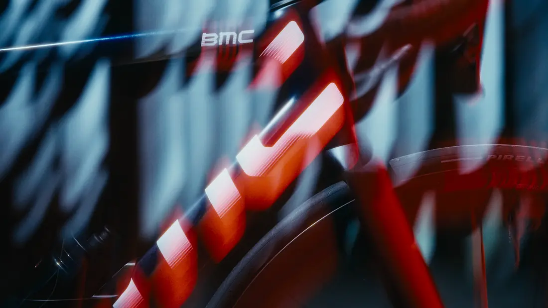 Rennradfahrer in voller Fahrt auf einer Landstraße, BMC Teammachine